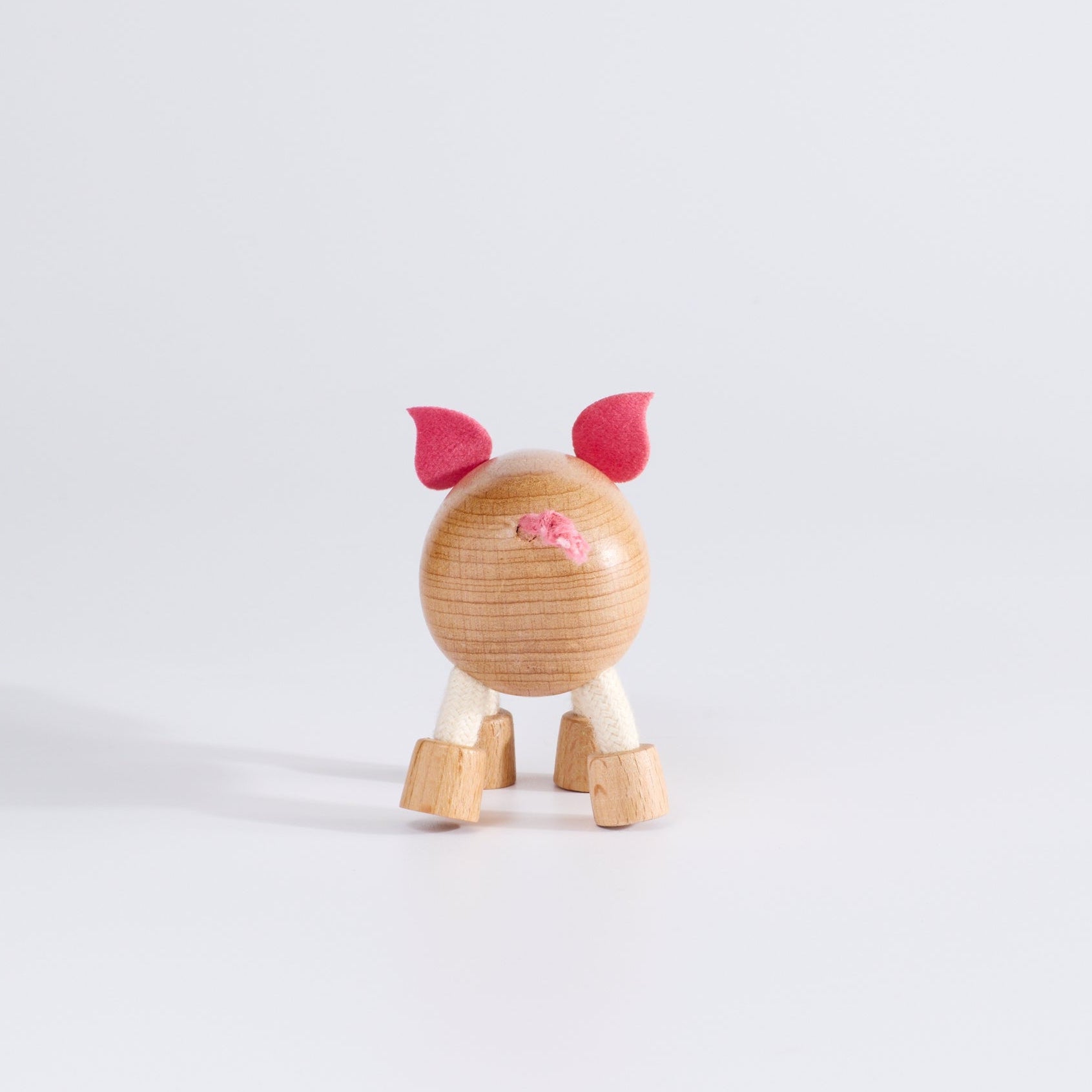 Wooden pig toy with fabric ears and rope tail