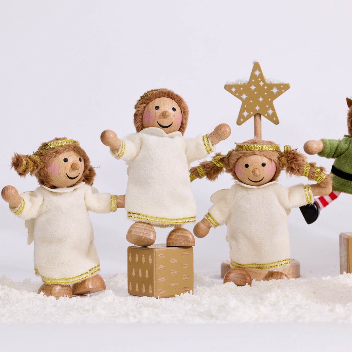Three Cherub Angels in white and gold dresses with a gold star and present block in a snowy Christmas scene