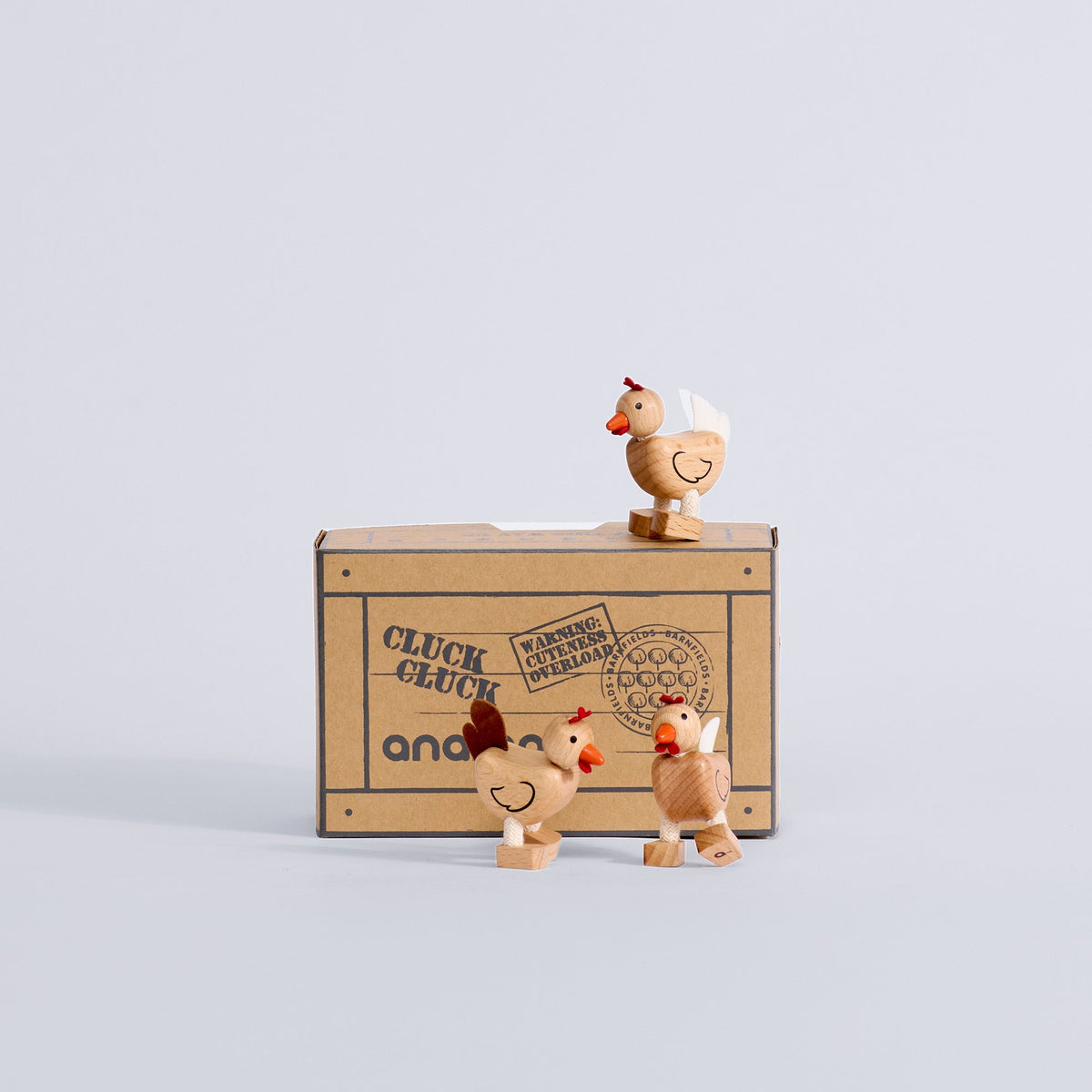 Three Chicken Trio wooden chickens displayed with their box