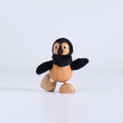 Wooden toy penguin on a white background