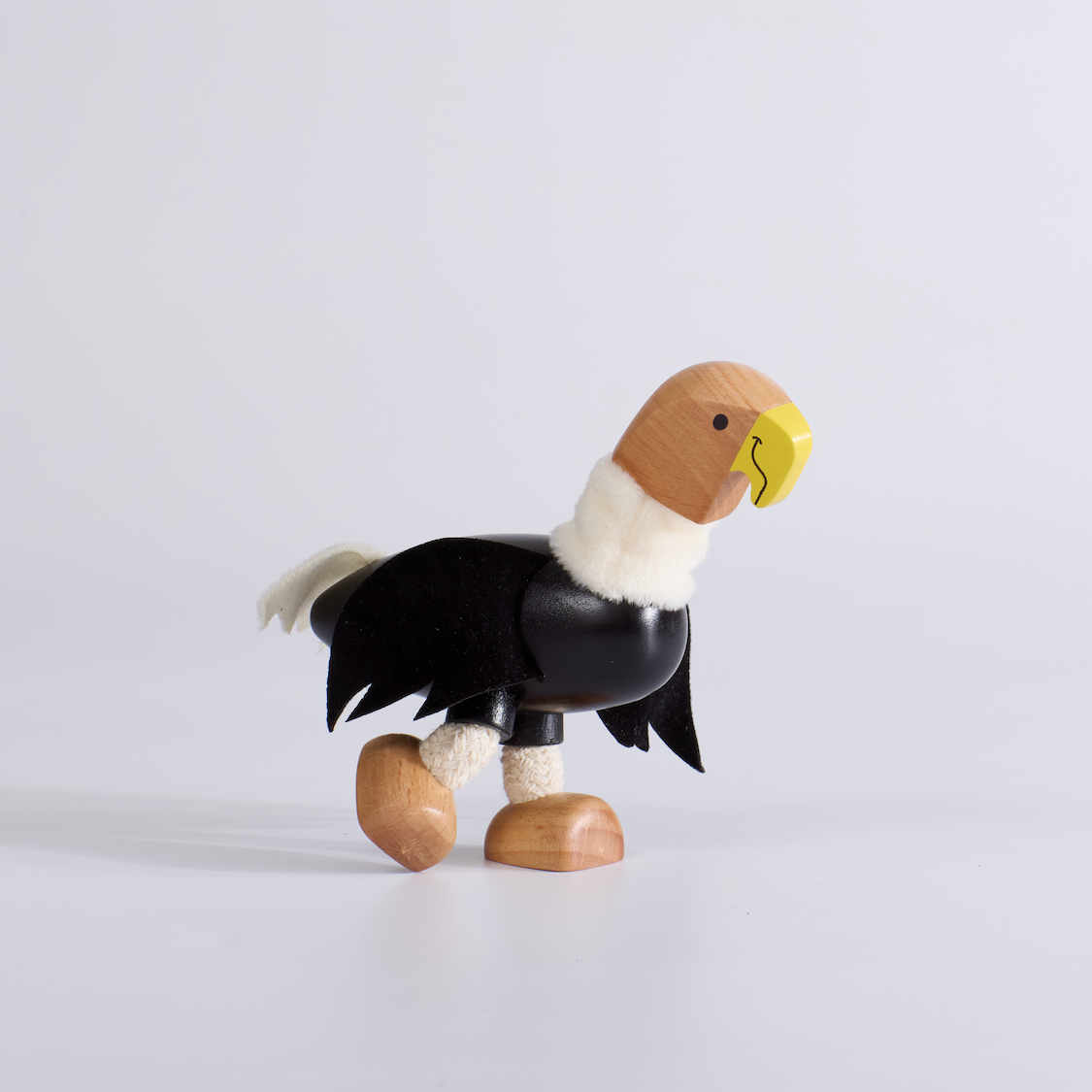 Wooden toy eagle figure on a light gray background