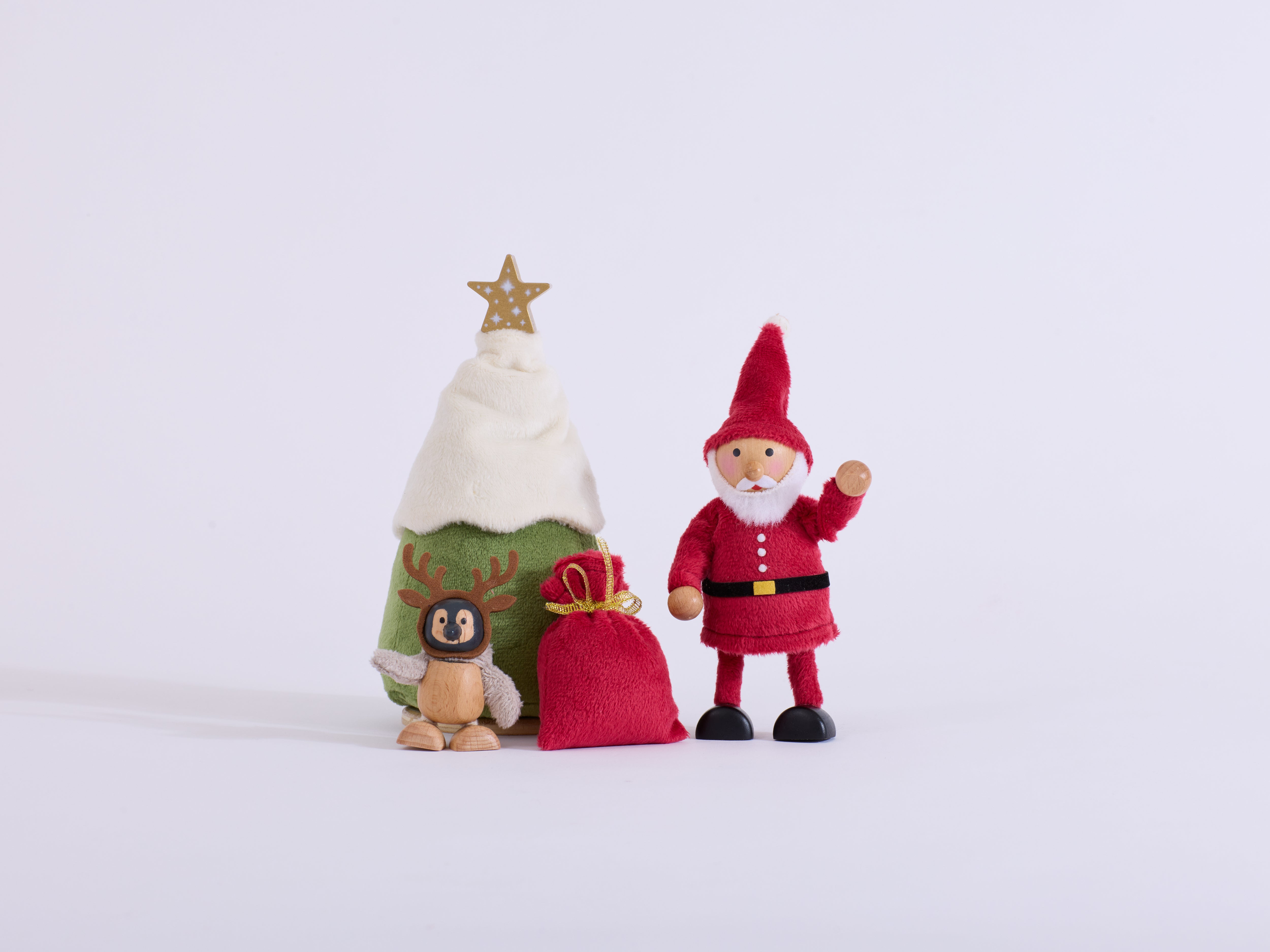 Santa waving beside the Christmas tree, red gift sack and penguin wearing reindeer antlers